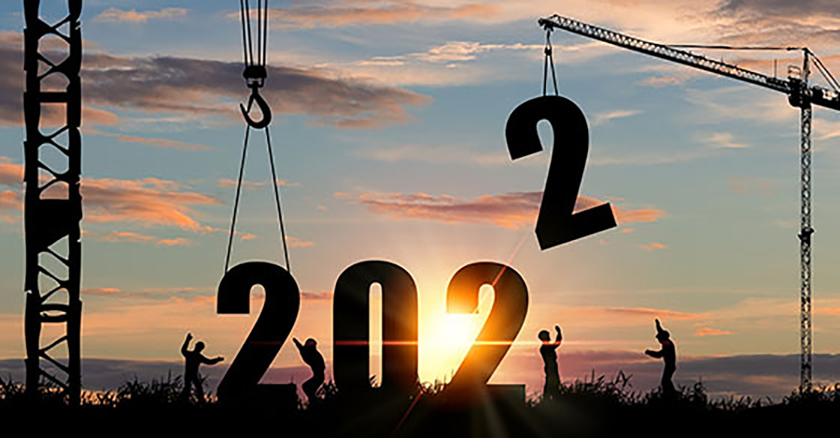 Image of the number 2022 being constructed with a sunrise behind it