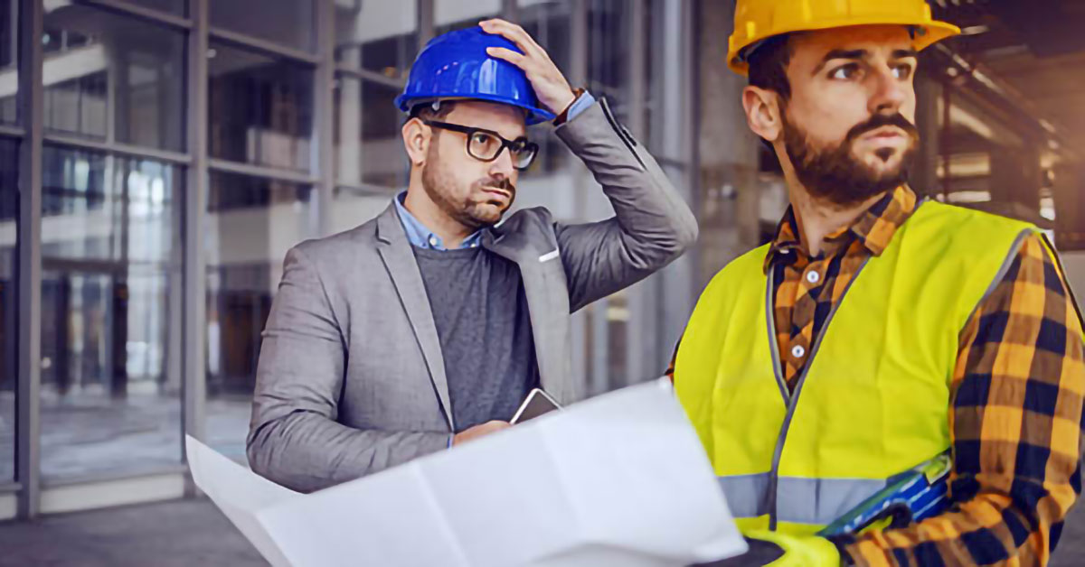 Image of contractors looking over plans and being a little stressed