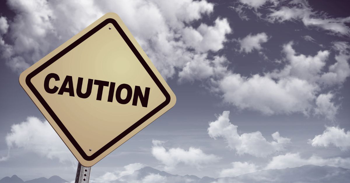 Image of a caution sign against a cloudy sky