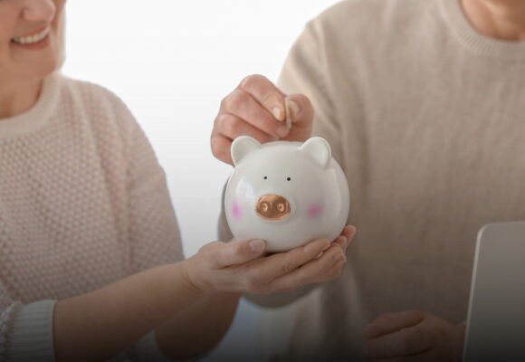 Image of retirees holding a piggy bank