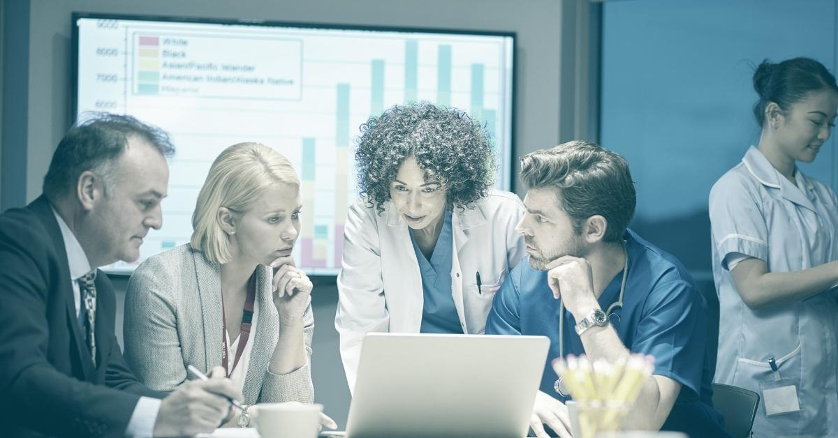 Image of doctors and healthcare admins looking at a laptop