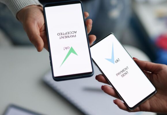 Image of hands holding phones with 'payment sent' and 'payment selected' on their screens