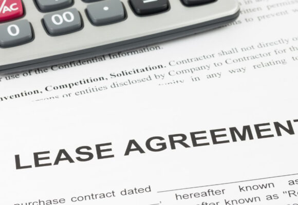 Image of a desk with a calculator and a Lease Agreement