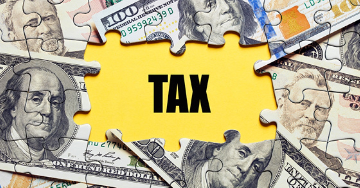Image of puzzle shaped money and the word 'tax'