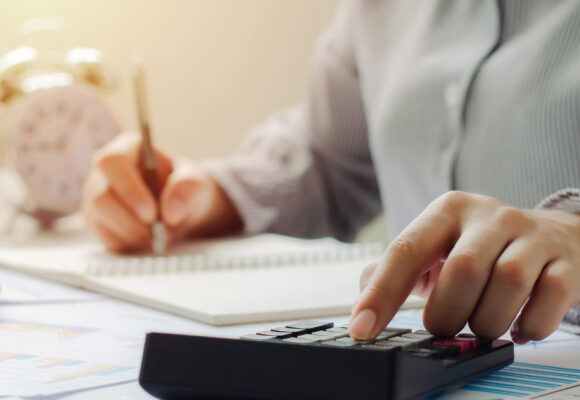 Image of a person doing paperwork and using a calculator