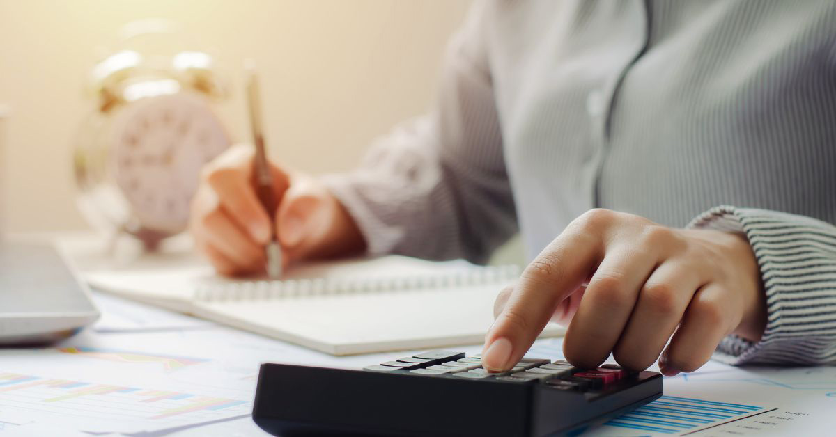 Image of a person doing paperwork and using a calculator