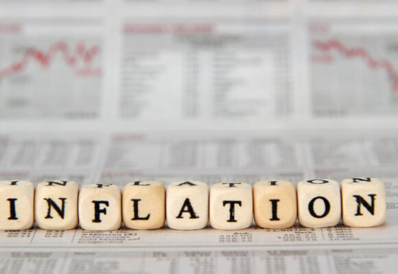 Image of financial charts with blocks that spell out 'Inflation'