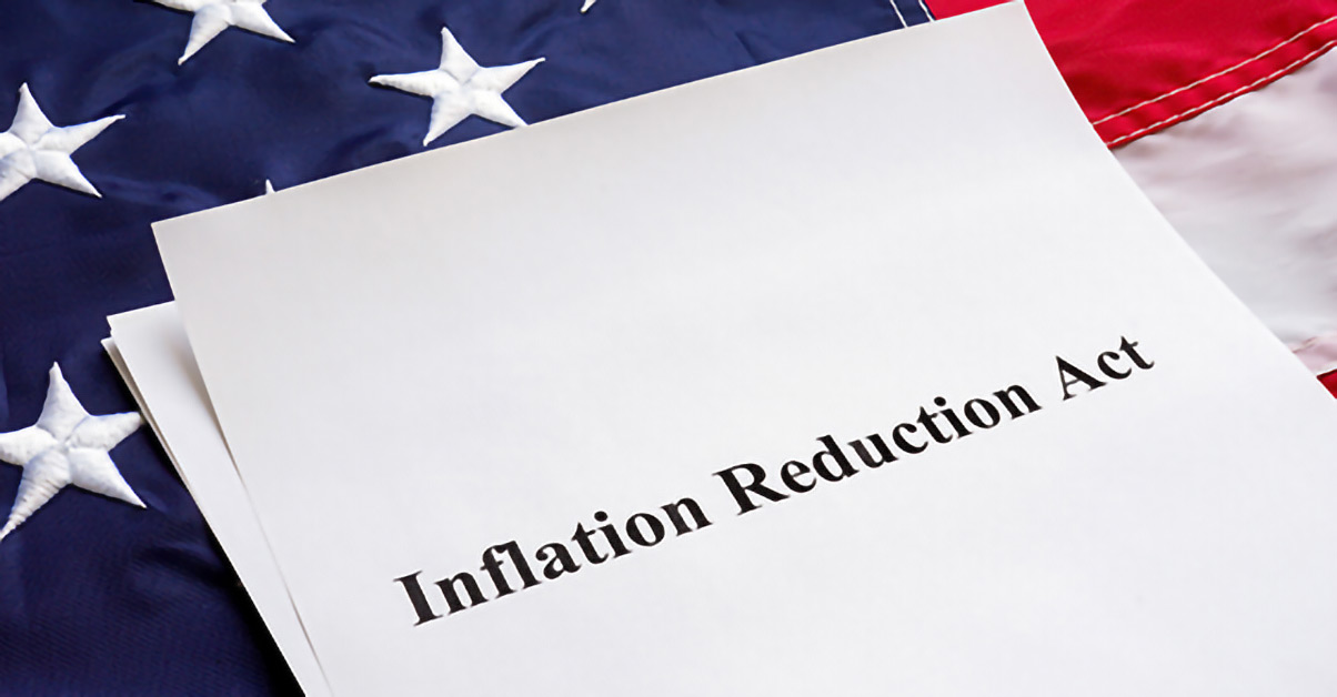 Image of the American flag with paper that says 'Inflation Reduction Act'