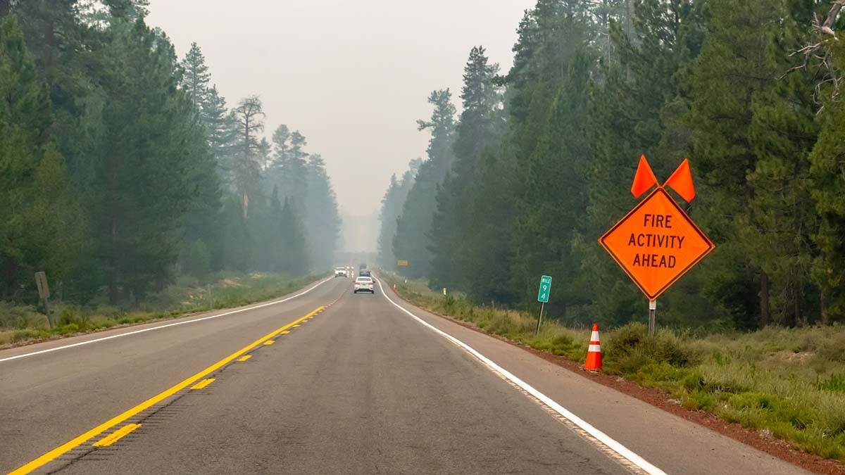 Image of a mountain road with caution signs