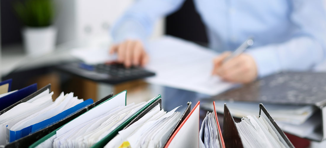 Photo of employee working at desk preparing for the company's first retirement plan audit