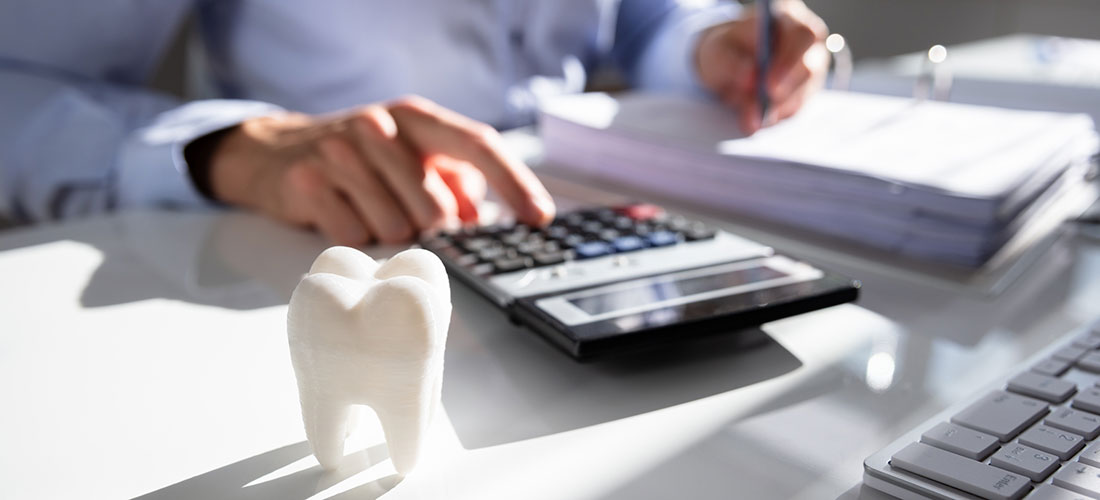 photo of dentist at desk with calculator planning for retirement