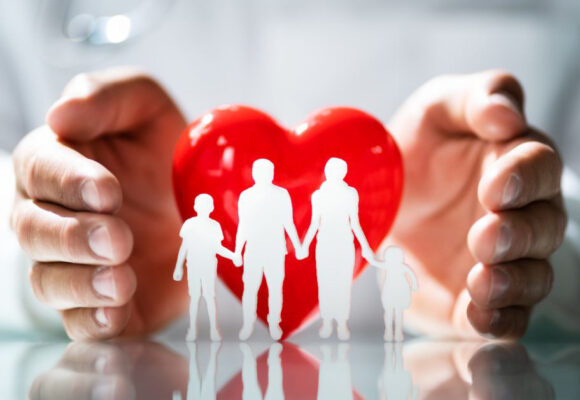 Image of a heart paperweight with small people-figures in front of it